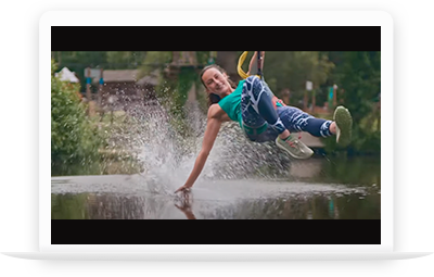 Une fille fait de la tyrolienne au dessus de l'eau